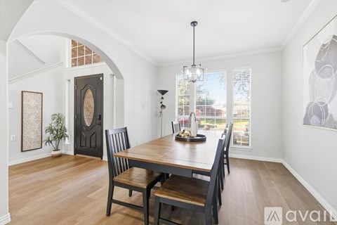 A dining room with a wooden table and chairs.