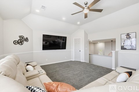 A living room with a white couch and a ceiling fan.
