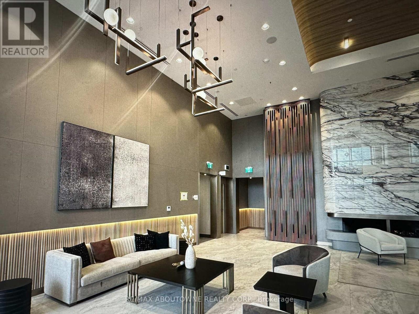A modern living room with a striped sofa and a marble fireplace.