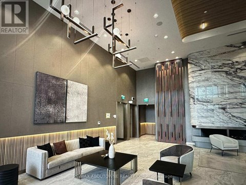 A modern living room with a striped sofa and a marble fireplace.