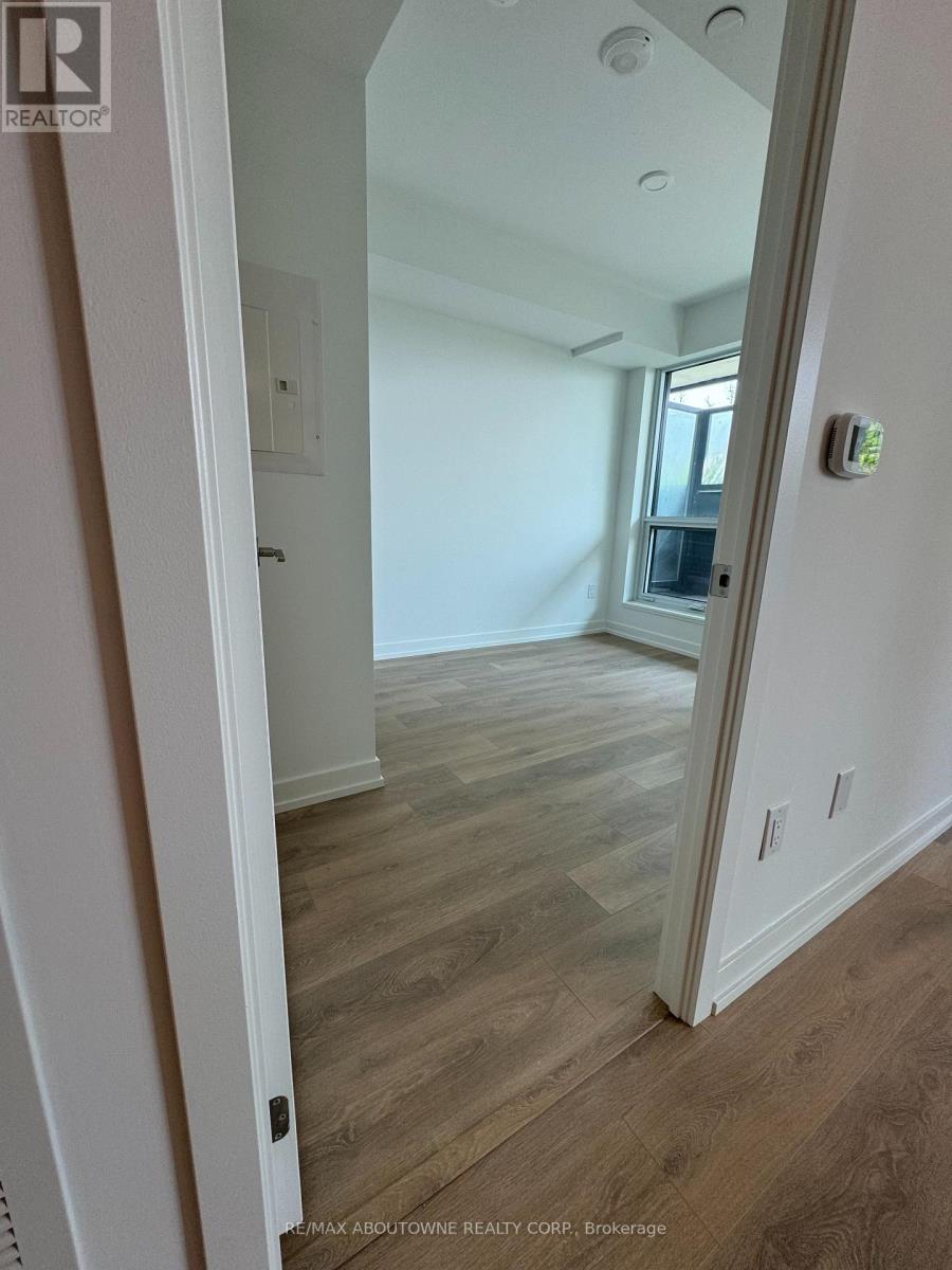 A room with wood flooring and a doorway leading to another room.
