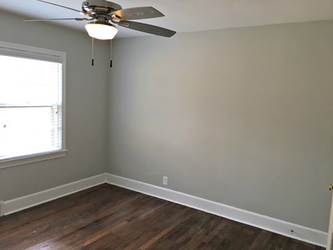A room with a ceiling fan and a window.