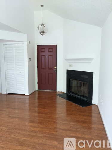 A room with a red door and a fireplace.