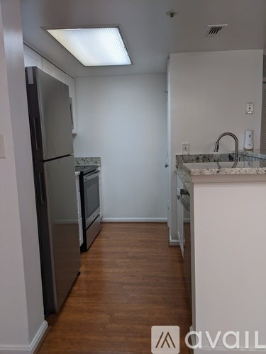 A kitchen with a refrigerator, oven, and sink.