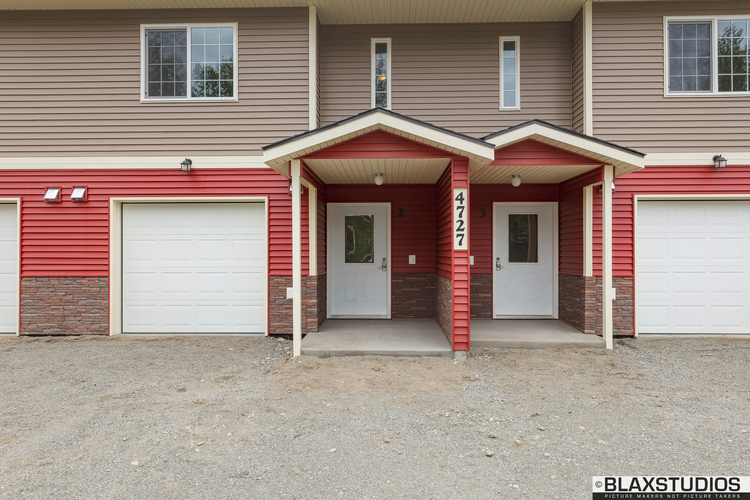 A two-story house with a red garage door.
