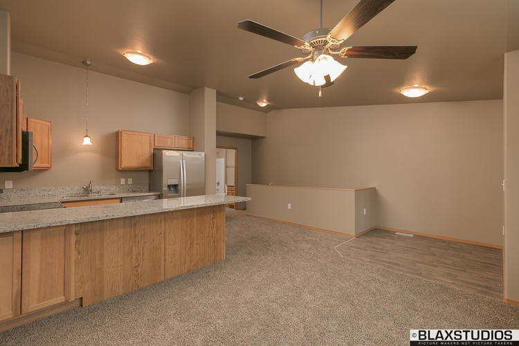 A kitchen with a ceiling fan and a counter top.