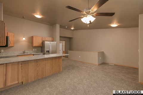 A kitchen with a ceiling fan and a counter top.