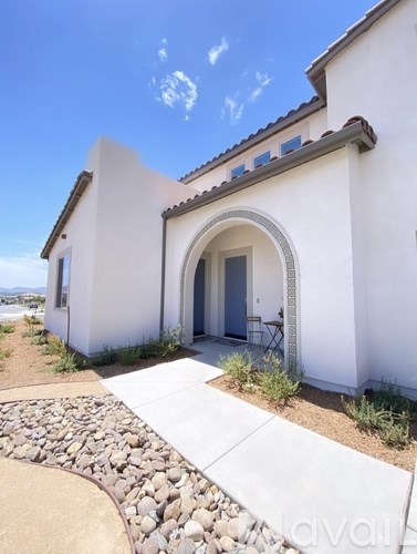 A white house with a stone pathway leading to the entrance.