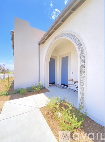 A white building with a blue door and a white archway.