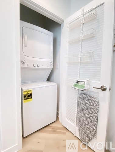 A white refrigerator with a freezer drawer and a door open to a kitchen.