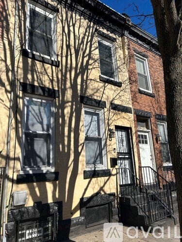 A row of houses with a tree in front of them.