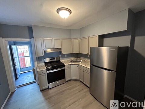 A kitchen with a stainless steel refrigerator and a stove top oven.