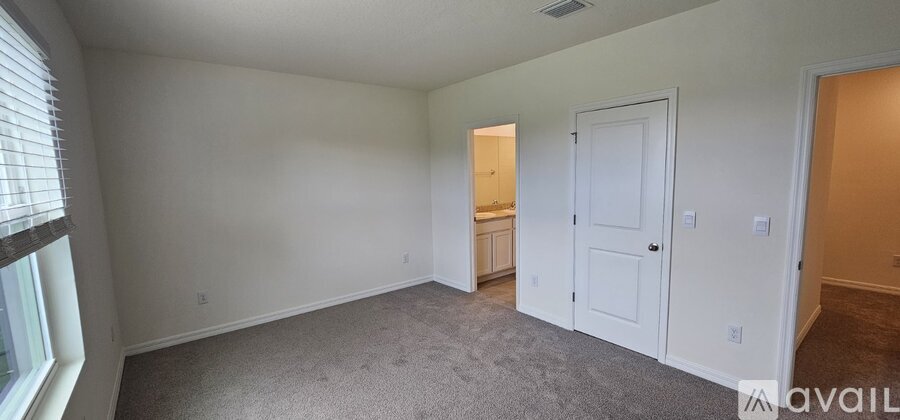 A spacious room with a carpeted floor and white walls.