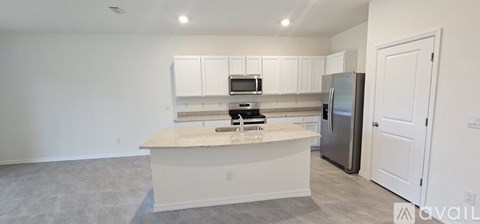 A kitchen with white cabinets and a marble countertop.