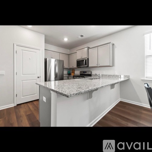 A kitchen with a granite countertop and stainless steel appliances.
