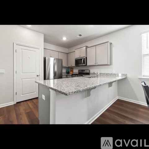 A kitchen with a granite countertop and stainless steel appliances.