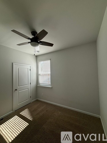 A room with a ceiling fan and a door.
