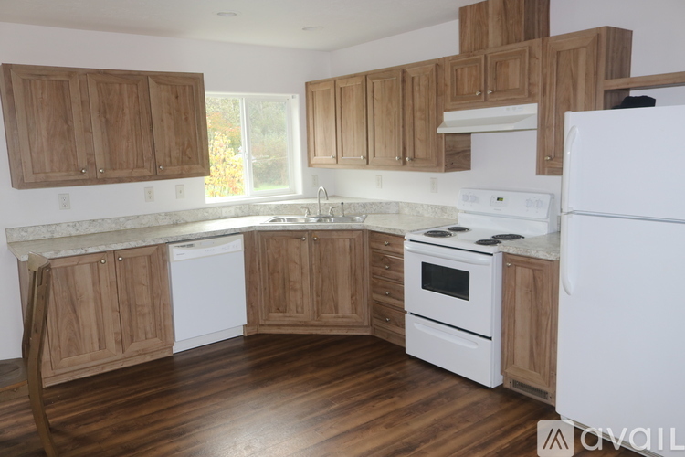 A kitchen with wooden cabinets and white appliances.