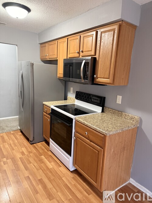 A kitchen with wooden cabinets and a granite countertop.
