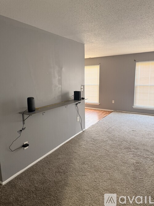 A room with a carpeted floor and a wall-mounted speaker system.