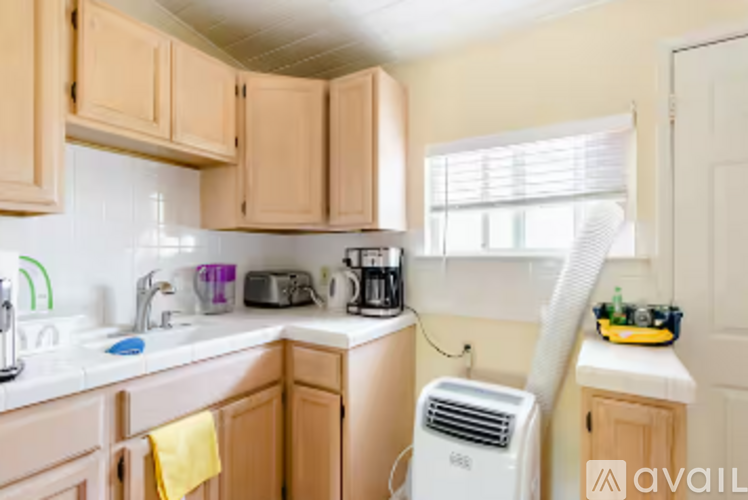 A kitchen with wooden cabinets and a white air conditioner.