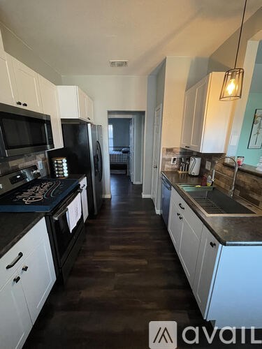 A kitchen with black countertops and white cabinets.