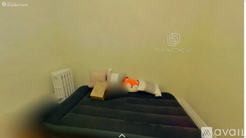 A bed with a green mattress and a white pillow is in a room.