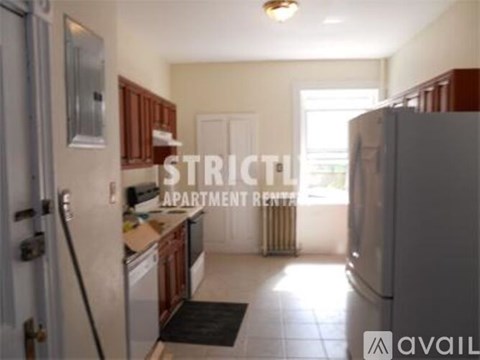A kitchen with a refrigerator, sink, and cabinets.