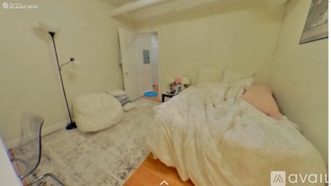 A bedroom with a bed, a lamp, a chair, and a rug.