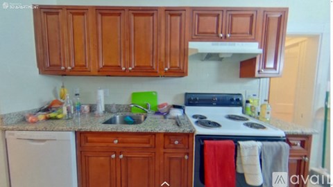 A kitchen with wooden cabinets and a white stove top oven.