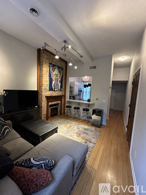 A living room with a grey couch and a fireplace.