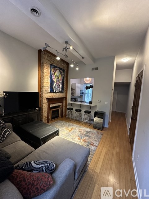 A living room with a grey couch and a fireplace.