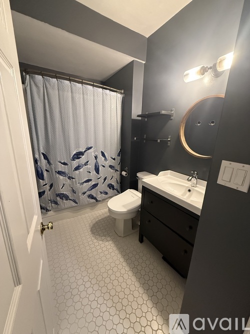 A bathroom with a toilet, sink, and shower curtain.