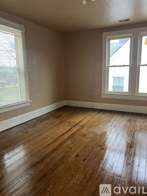 A room with wooden flooring and a window.