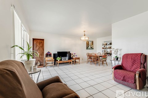A living room with a brown couch and a red chair.