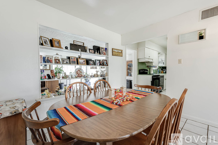 A dining room with a wooden table and chairs.