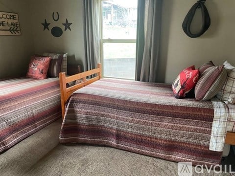A bedroom with two beds and a dog-themed decoration on the wall.