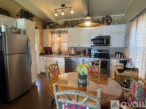 A kitchen with a wooden table and chairs.