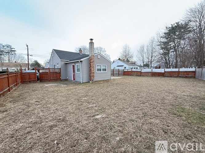 A backyard with a fence and a house in the background.