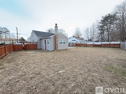 A backyard with a fence and a house in the background.