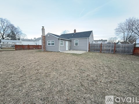 A backyard with a house and a fence.