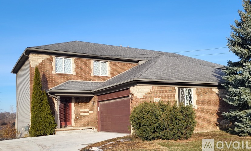 A two-story house with a garage and a driveway.