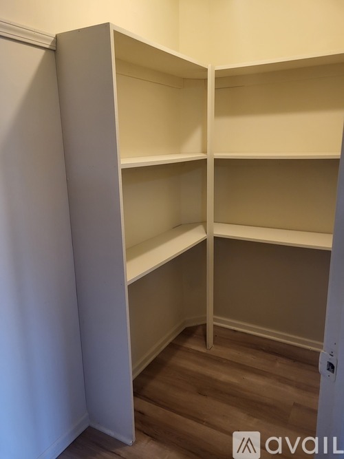 Empty shelves in a room with wooden flooring.