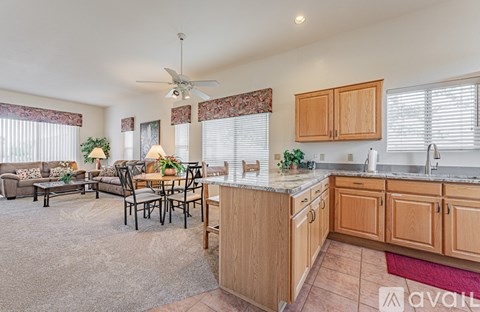 A kitchen with wooden cabinets and a dining table with chairs.
