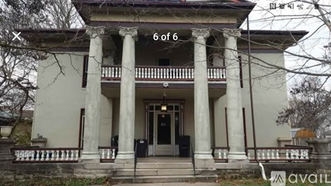 A white house with six pillars in front.