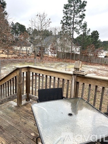 A deck with a hot tub and a black chair.