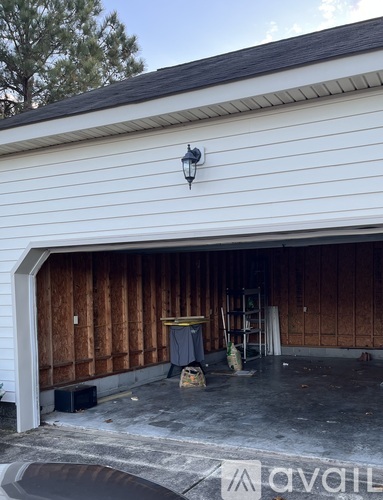 A garage door is open and the garage is under construction.