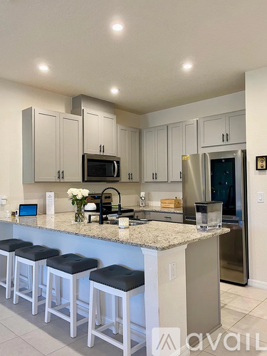 A kitchen with a granite countertop and stools.