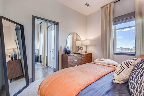 A bedroom with a large bed and a view of the city.