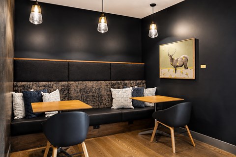 A black and wood themed dining area with a bench, table and chairs.